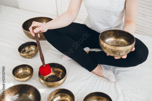 Принти на полотні Massage therapist plays on singing bowls for a vibrational massa