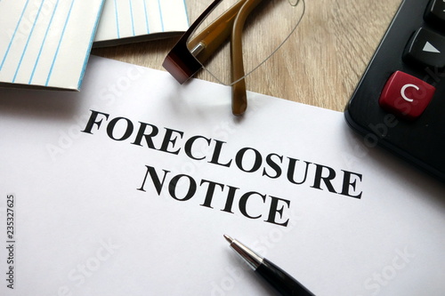Foreclosure notice with pen, calculator and   glasses in office photo