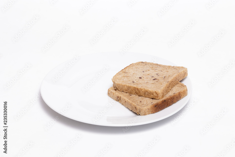 Full grain bread slices on a white dish against white background