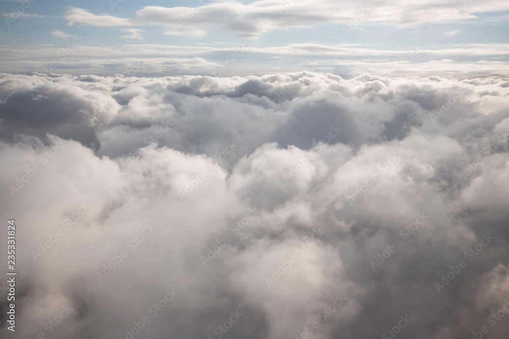 Layer of clouds taken from aircraft above scene illuminated by low evening or morning sun rays of warm golden color. Easy background photography of simple composition and empty space. Layer of clouds taken from aircraft above scene illuminated by low evening or morning sun rays of warm golden color. Easy background photography of simple composition and empty space.