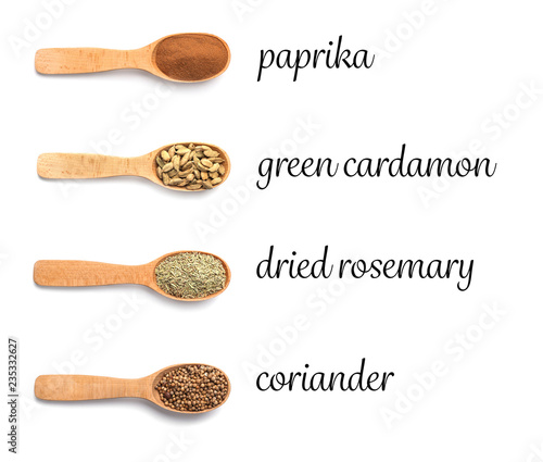 Wooden spoons with different spices and herb on white background, top view. Collection with names