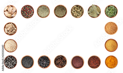 Frame of wooden bowls with different spices and herbs on white background, top view. Large collection with space for design