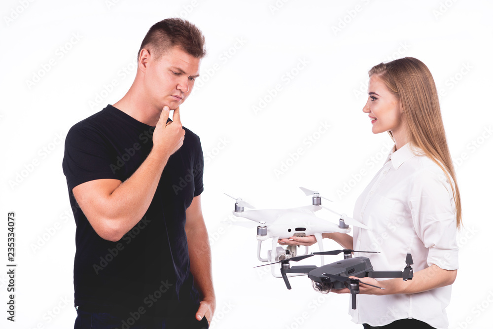 Obraz premium Beautiful boy chooses flying drones. Holding his head. On a white background. Theme selling and buying drone 