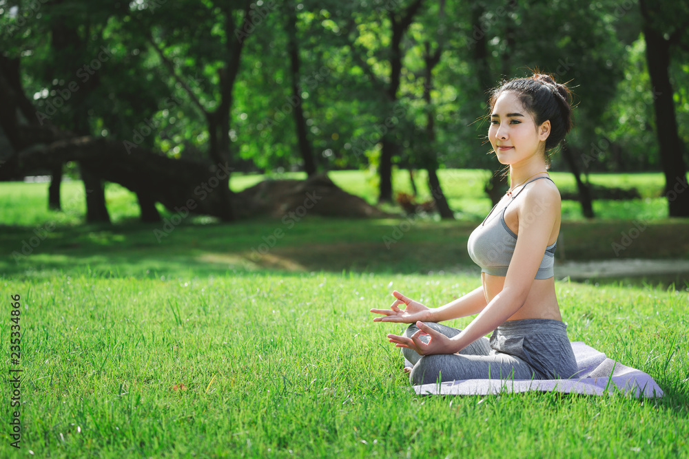 Fitness asian woman doing yoga in park