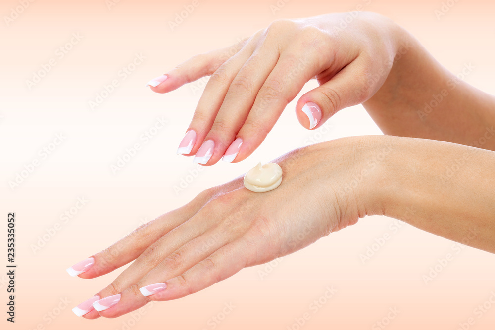 Well-groomed female hands with a cream on one of them. Skin care concept
