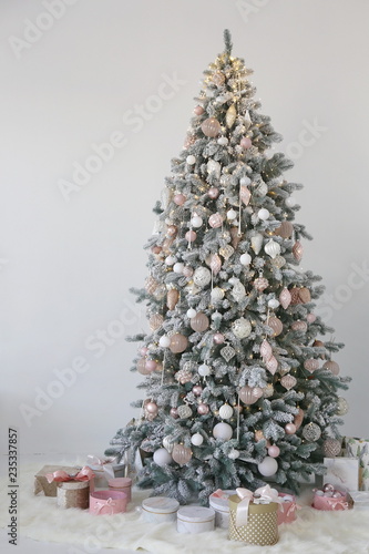 new year and Christmas tree with white and pink toys and gift boxes