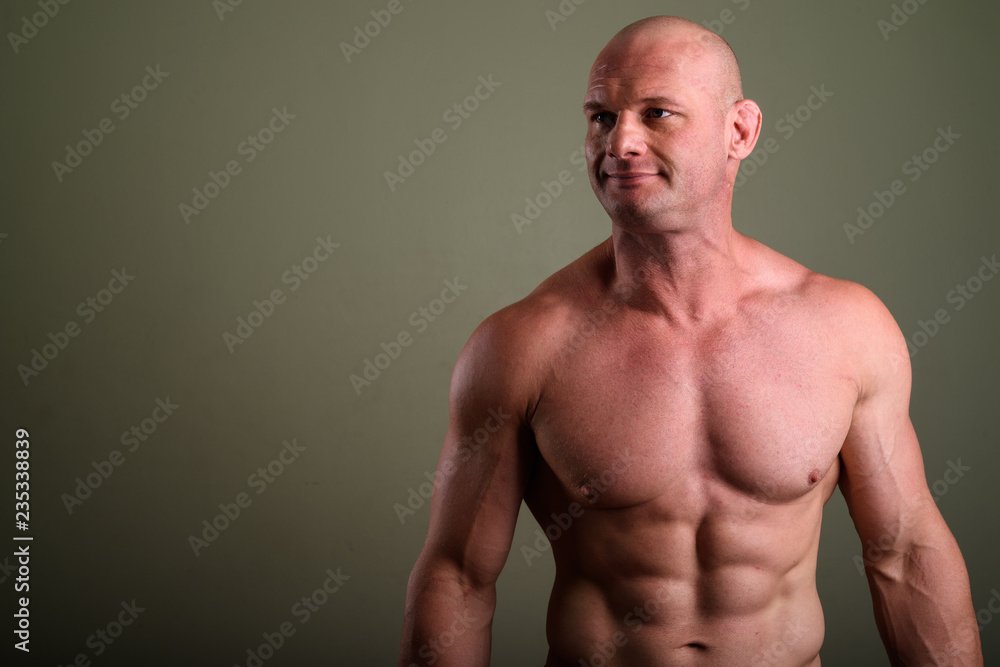 Fototapeta premium Bald muscular man shirtless against colored background