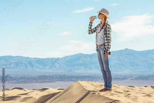 Obraz na plátně Woman drinking water in desert