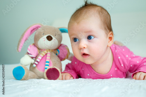 Portrait of a cute newborn baby girl lying on her stomach