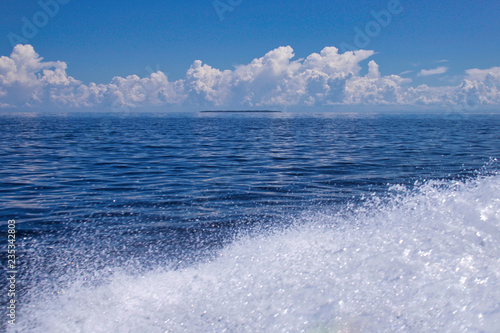 foam of a boat in the celebes sea, kalimantan, borneo, small island on the background