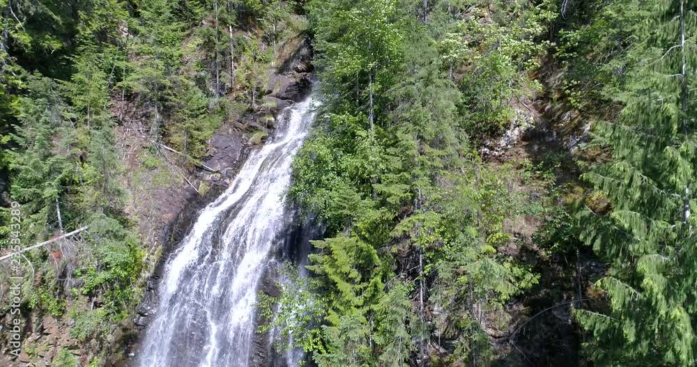 Majestic waterfall in Nakusp, Vancouver, Canada. Drone flying. Aerial view with mountain background. Majestic waterfall in Nakusp, Vancouver, Canada. Drone flying. Aerial view with mountain background.