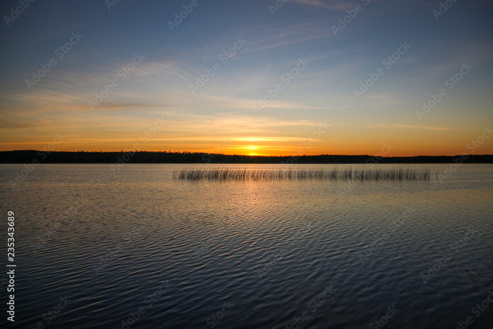 Obraz premium Sunset on the lake every minute changes the color scheme