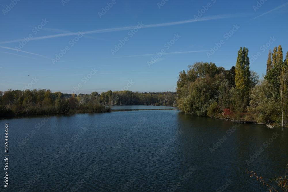 Obraz premium Blick auf einen von Wald umgebenen See mit Holzsteg