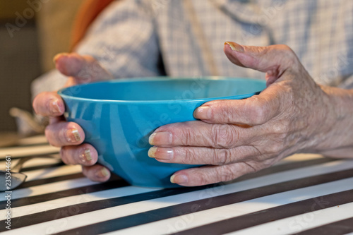 elderly woman holding a bowl of soup