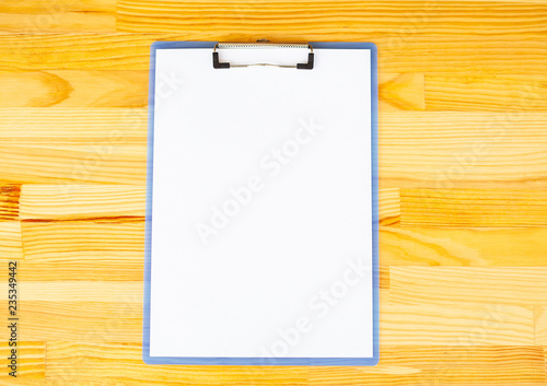 Office Hand Holding a Folder with a White Color Paper on the Background of the Wooden Table. Copyspace. Place for Text