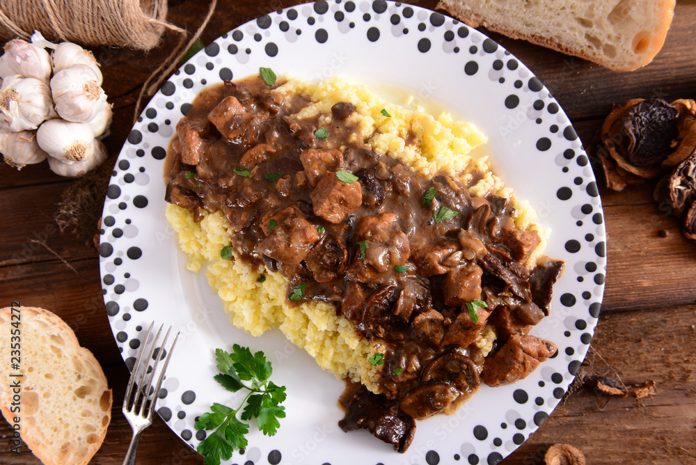 Stew with meat, mushrooms and vegetables served with groat Stew with meat, mushrooms and vegetables served with groat