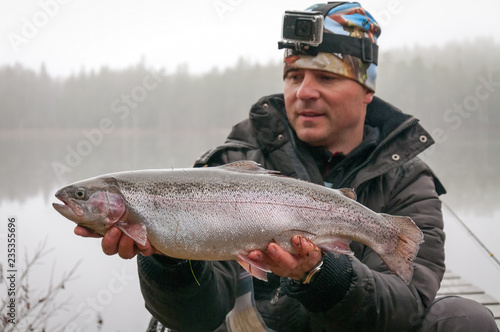 Angler with autumn fly fishing trophy - rainbow trout