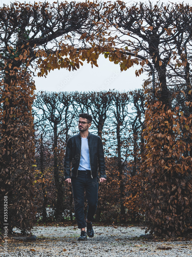 Fototapeta premium young man with glasses walking in park in winter