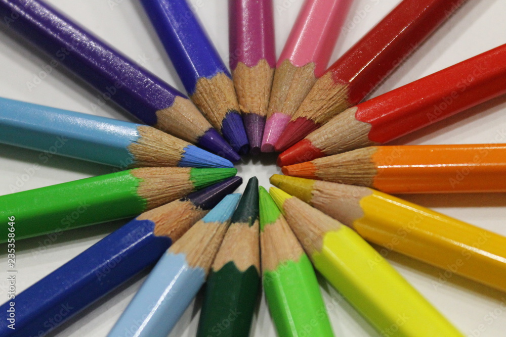 colored pencils lying around the heart on a white background colored pencils lying around the heart on a white background