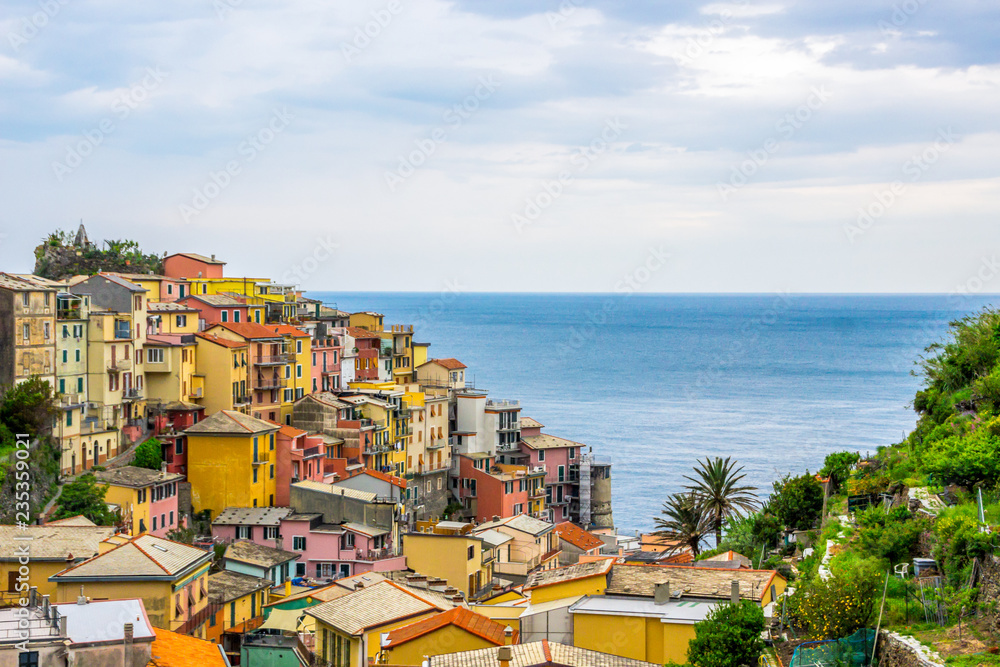beach streets and colorful houses on the hill in Manarola in Cinque Terre in Italy 