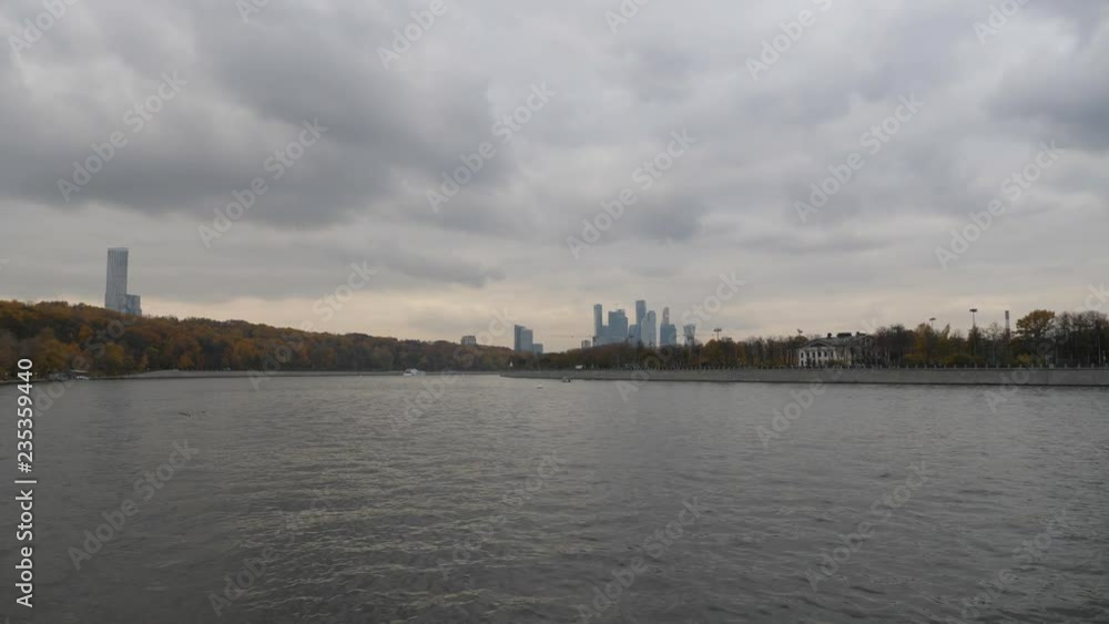 Moscow city view from the river. Late autumn in the capital's quays. Navigable walking river. Tower construction cranes towering over the autumn city park. Late autumn in the capital's quays Moscow city view from the river. Late autumn in the capital's quays. Navigable walking river. Tower construction cranes towering over the autumn city park. Late autumn in the capital's quays