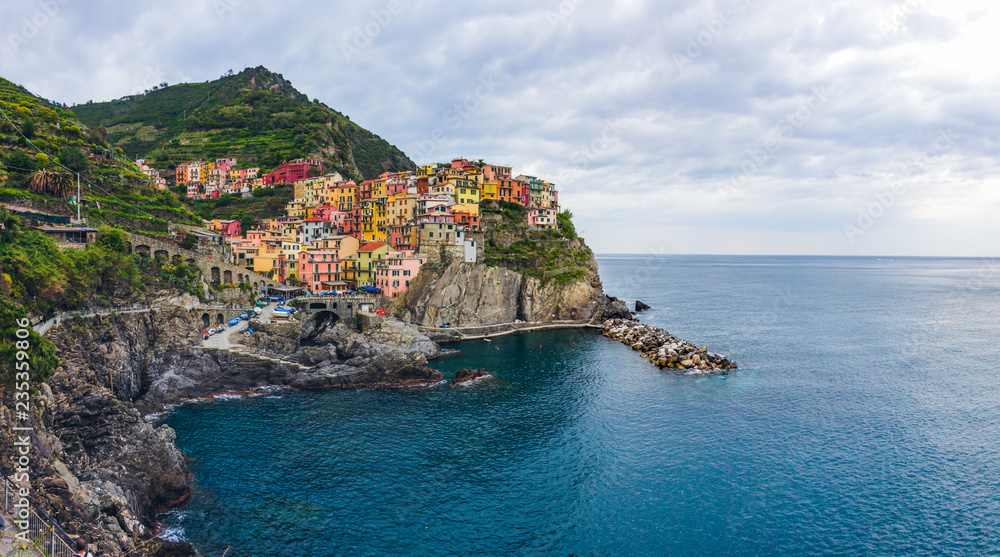 beach streets and colorful houses on the hill in Manarola in Cinque Terre in Italy 