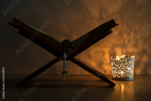 Quran and rosary beads on the white background with light lantern or candle for Islamic concept. Holy book Koran for Muslims holiday, Ramadan,blessed Friday message and three months