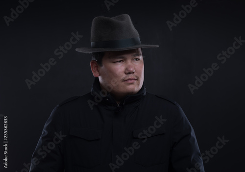 classic portrait of asian man in hat on black studio background