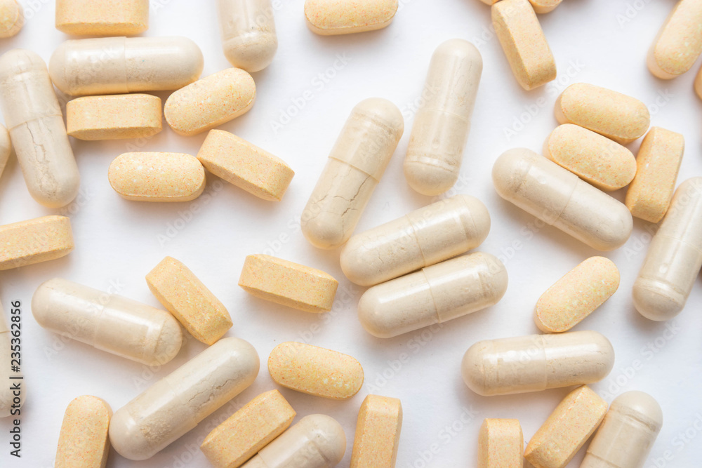 Medicine yellow pills or capsules on a white background close-up. vitamins Drug prescription of drugs for treatment. Pharmaceutical drug, cured in a container for health. Antibiotic drugs. Medicine yellow pills or capsules on a white background close-up. vitamins Drug prescription of drugs for treatment. Pharmaceutical drug, cured in a container for health. Antibiotic drugs.