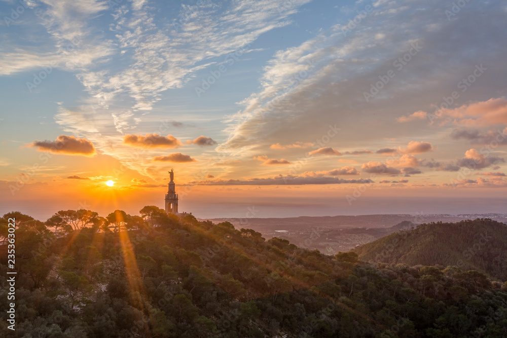 Sunrise over the statue of Christ at the Sant Salvador sanctuary and monastery, Mallorca