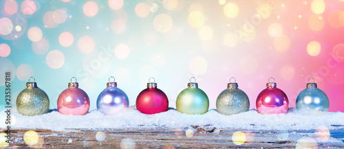 Colorful Baubles On Snow In Shiny Background
