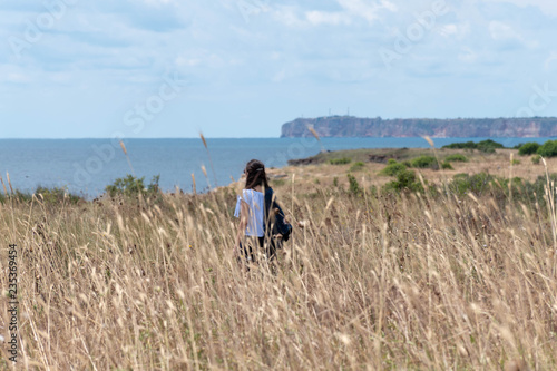 Soft focus image of a girl trekking by the sea