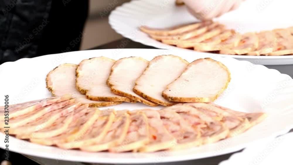 Cook arranges slices of baked meat and roulade of chicken on a plates Cook arranges slices of baked meat and roulade of chicken on a plates