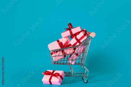 Holiday sales, concept. A lot of pink gift boxes in the shopping cart.