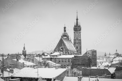 Krakow in Christmas time, aerial view on snowy roofs in central part of city. St. Mary's Basilica on Main Square. BW photo. Poland. Europe.