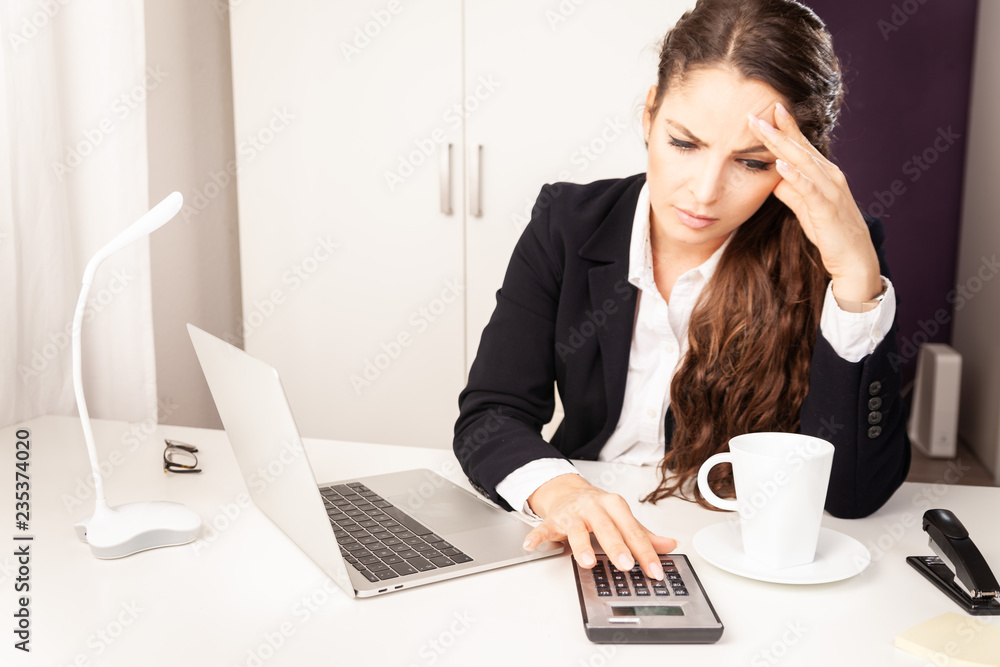 Young Business Woman working sitting at desk stressed out angry on laptop Young Business Woman working sitting at desk stressed out angry on laptop