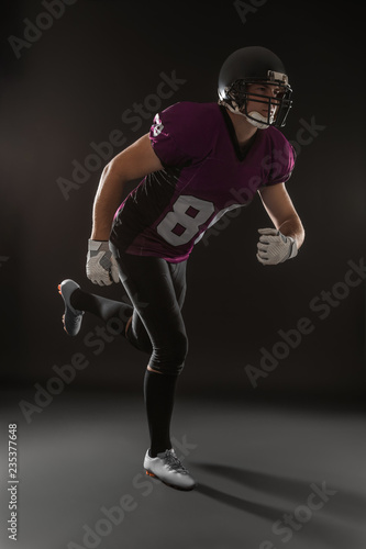 American football player wearing uniform on dark background © New Africa
