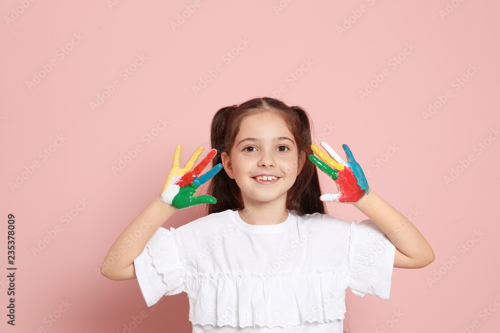 Little child with painted hands on color background