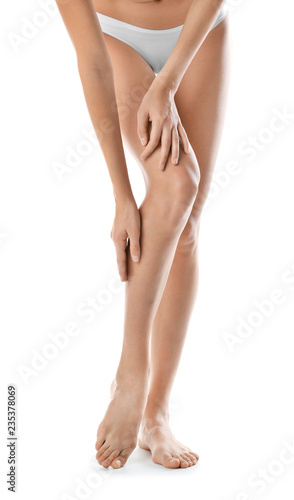 Young woman with beautiful long legs on white background, closeup