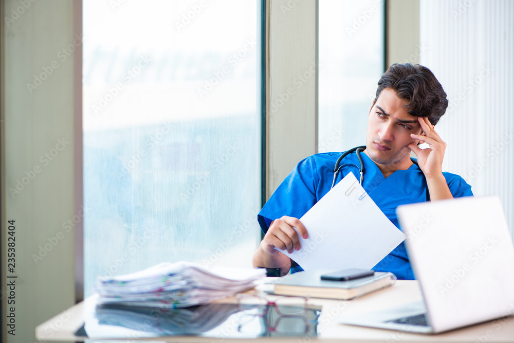 Young handsome doctor working in the hospital Young handsome doctor working in the hospital