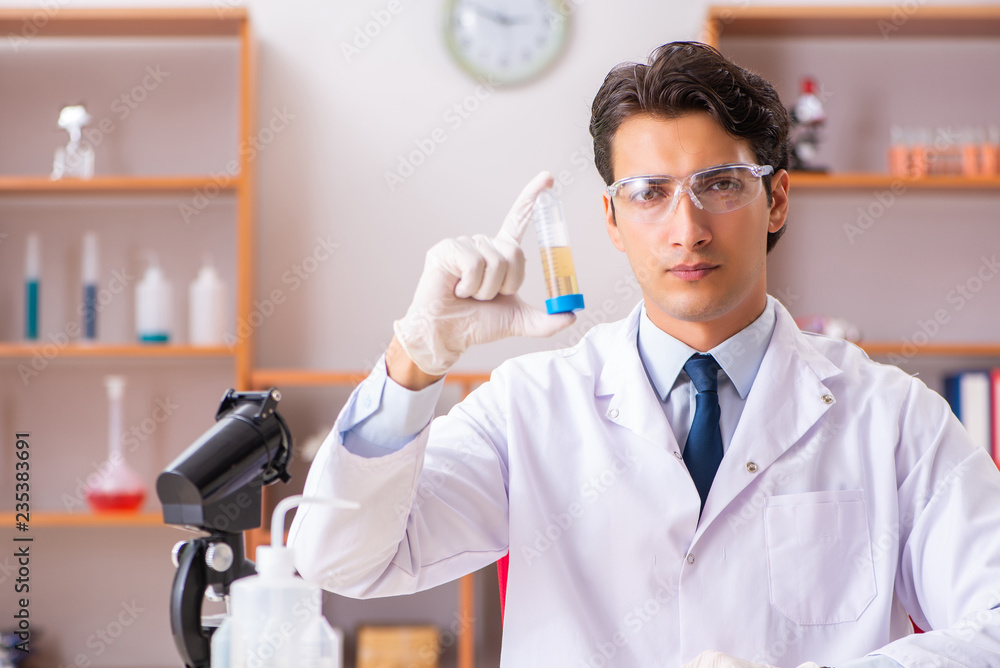 Young handsome biochemist working in the lab Young handsome biochemist working in the lab