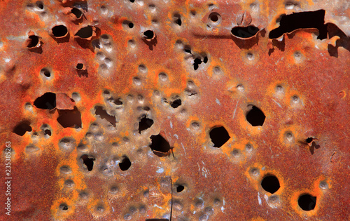 Obraz na plátně Bullet holes in rustic rusty car door background