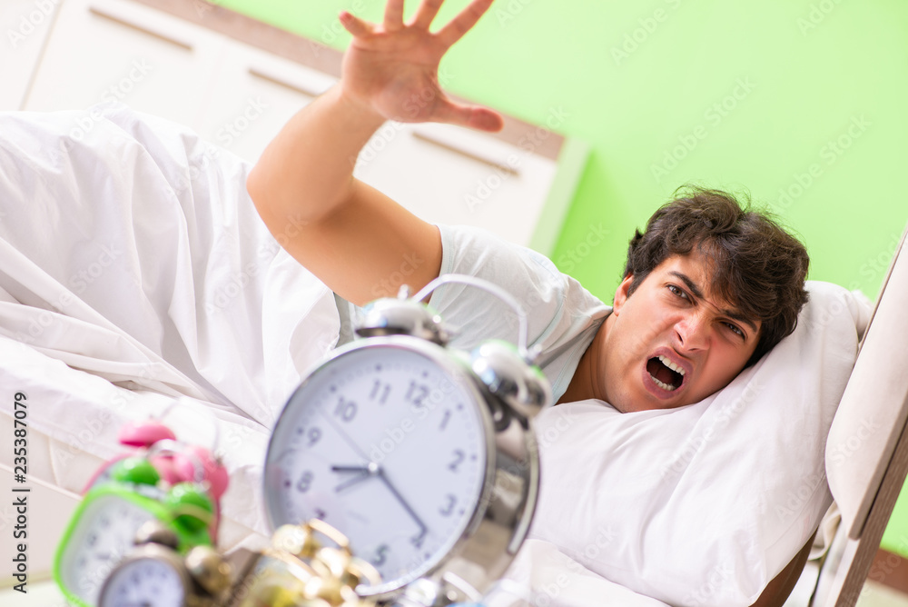 Obraz premium Young man having trouble waking up in early morning