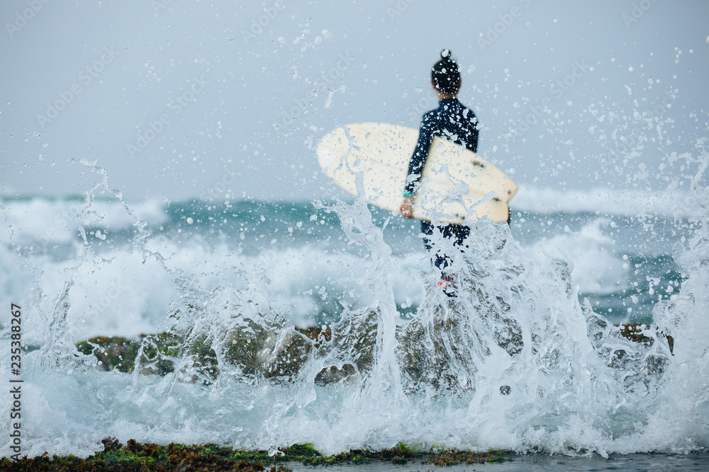 Naklejka premium Woman surfer with surfboard going to surf the big waves