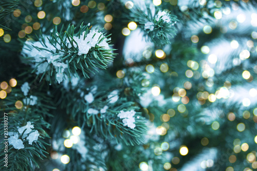 Closeup of Christmas tree with light, snow flake. Christmas and New Year holiday background. vintage color tone.