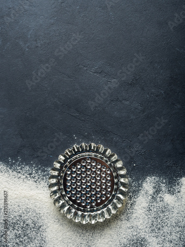 Baking accessories on black background with flour. Christmas winter dark background