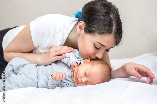 young mother is kissing her newborn son