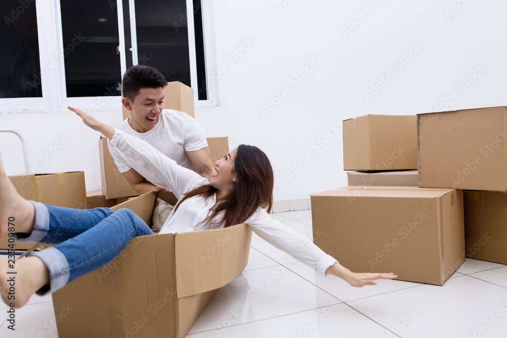Excited couple playing with a cardboard box Excited couple playing with a cardboard box