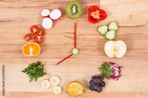 Fruits and vegetables in shape of clock, concept of time for healthy eating containing natural minerals