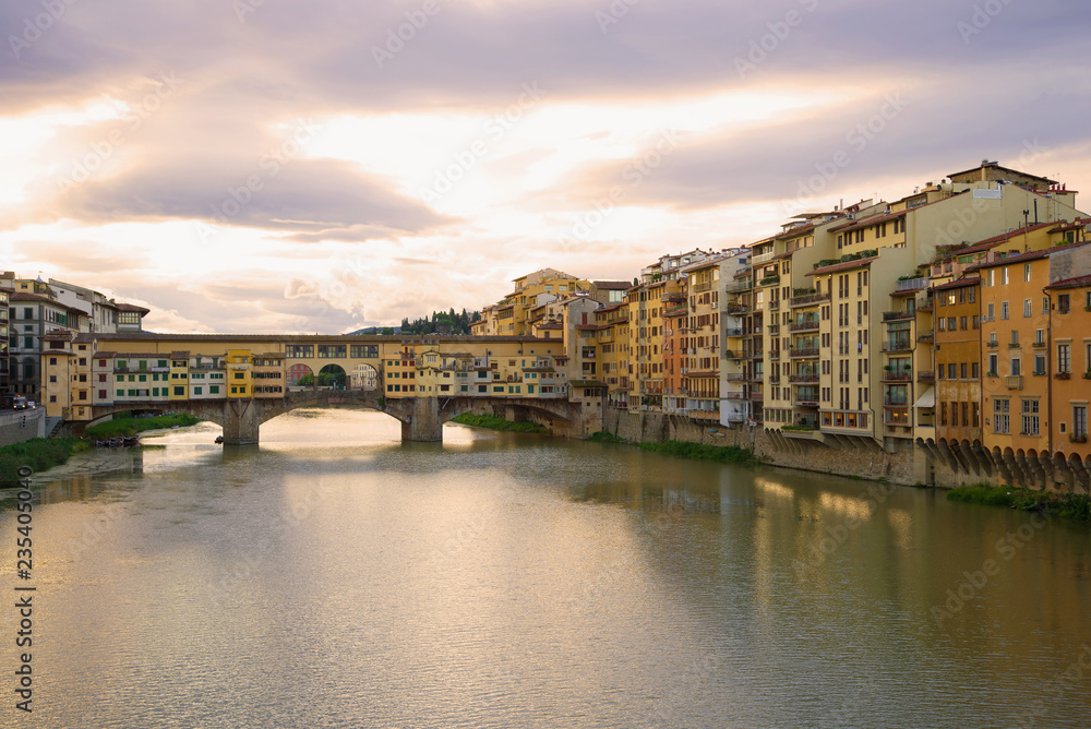 View of the Golden Bridge and the city embankment on a September cloudy morning. Florence, Italy